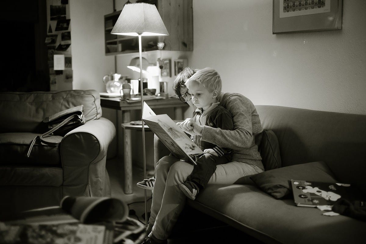 parent and child reading in living room